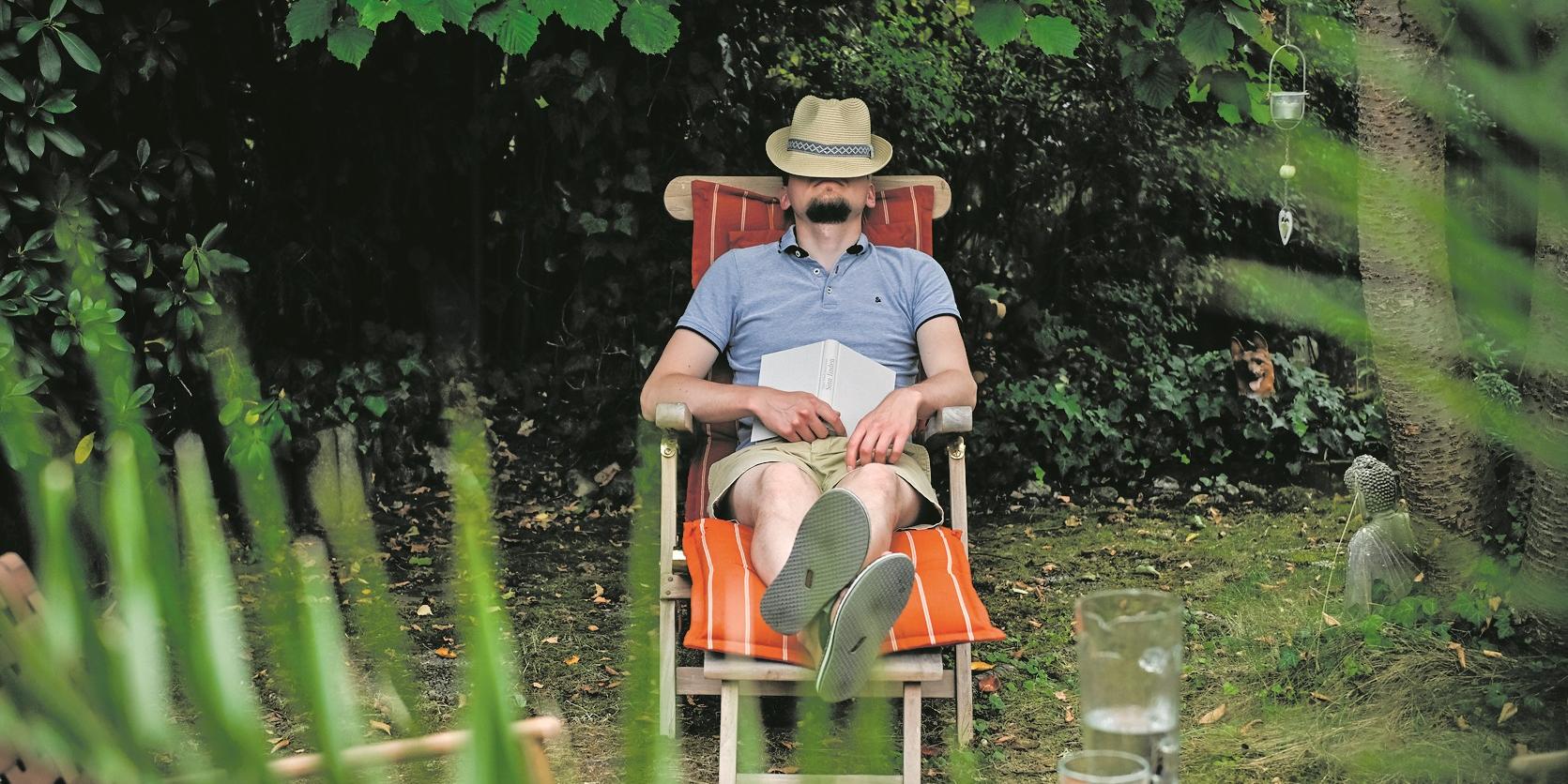 Ein Mann mit einem Hut auf dem Gesicht sitzt in einem Gartenstuhl und schläft, am 26. August 2025 in einem Garten in Bonn. Auf seinem Schoß liegt ein Buch. (c) Julia Steinbrecht/KNA Ein Mann mit einem Hut auf dem Gesicht sitzt in einem Gartenstuhl und schläft, am 26. August 2025 in einem Garten in Bonn. Auf seinem Schoß liegt ein Buch.