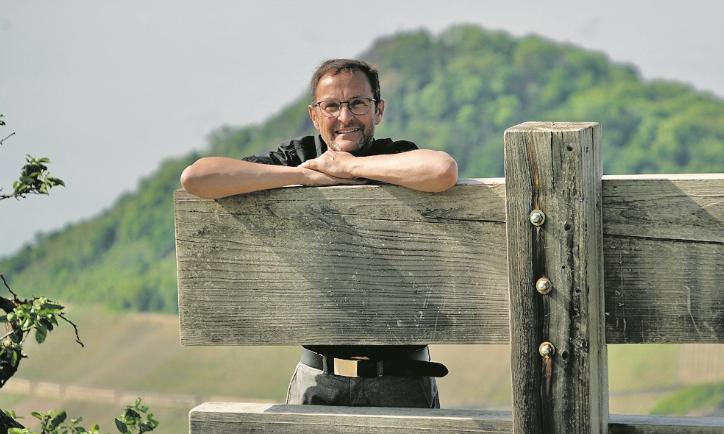 Der Pfarrer und Buchautor Jörg Meyrer stützt sich auf einer Holzkonstruktion ab.