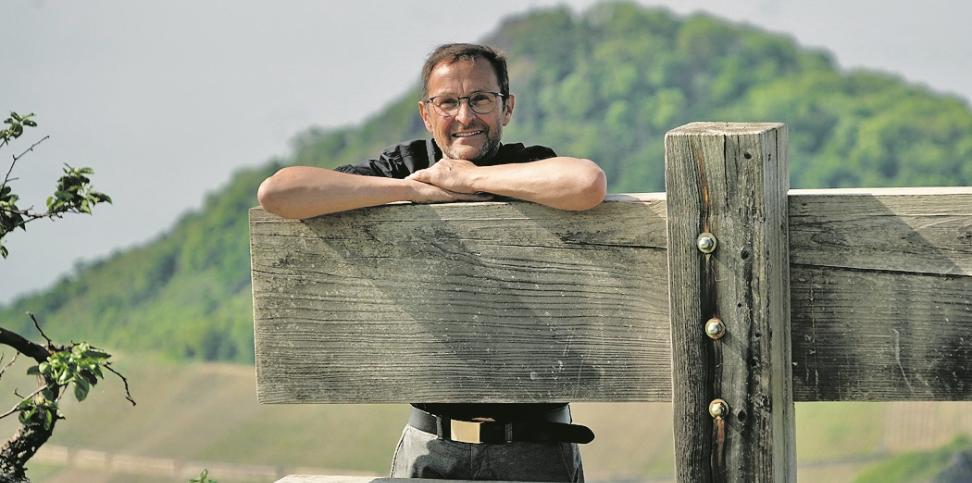 Der Pfarrer und Buchautor Jörg Meyrer stützt sich auf einer Holzkonstruktion ab.