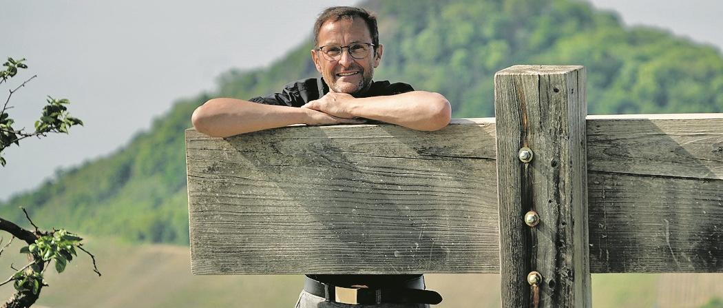 Der Pfarrer und Buchautor Jörg Meyrer stützt sich auf einer Holzkonstruktion ab.