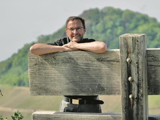Der Pfarrer und Buchautor Jörg Meyrer stützt sich auf einer Holzkonstruktion ab.