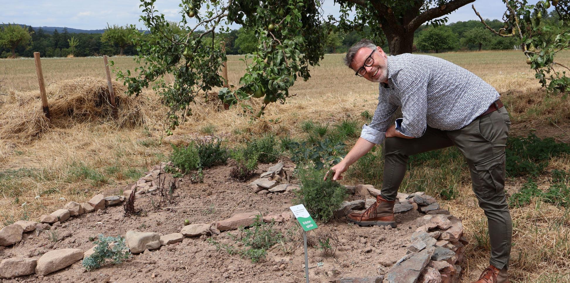 Christoph Halbe von den Lebenshilfe-Werken erklärt die Kräuterspirale am Hofgut Serrig