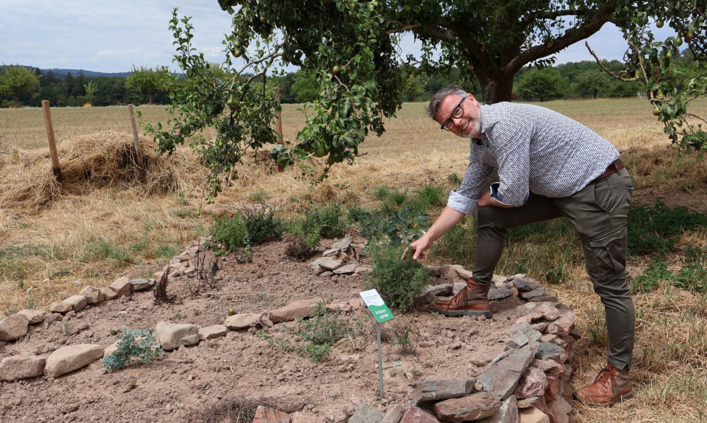 Christoph Halbe von den Lebenshilfe-Werken erklärt die Kräuterspirale am Hofgut Serrig