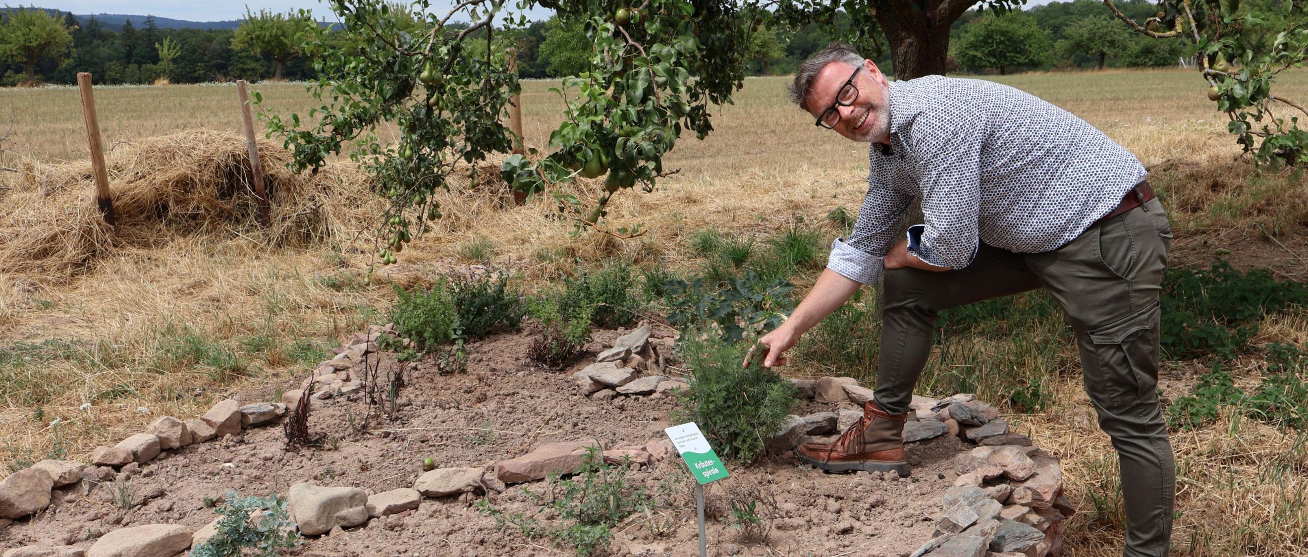 Christoph Halbe von den Lebenshilfe-Werken erklärt die Kräuterspirale am Hofgut Serrig