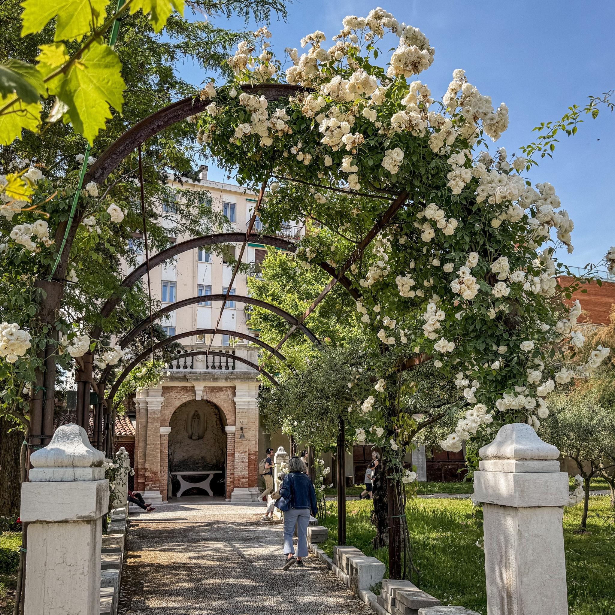 Eine Besucherin schlendert auf eine Kapelle zu im Mystischen Garten, einem Teil des Vatikan-Pavillons bei der Biennale in Venedig.