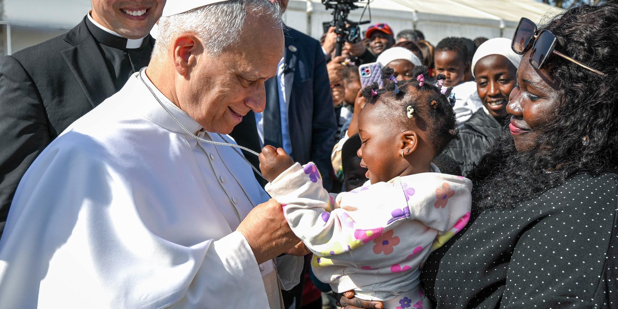 Ein Kleinkind auf dem Arm der Mutter und der Papst (c) Vatican Media/Romano Siciliani/KNA Ein Kleinkind auf dem Arm der Mutter und der Papst