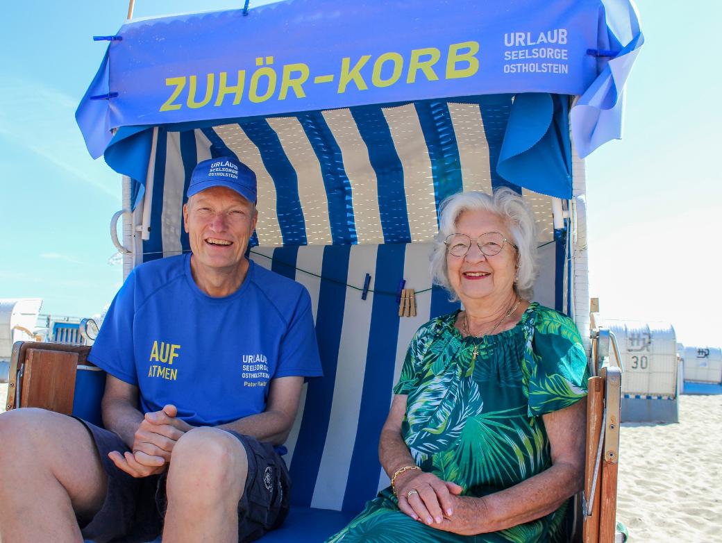 Urlauberseelsorger Pater Ralf Winterberg sitzt mit Touristin Anita Wendt im Ostseebad Dahme in einem „Zuhör-Korb“.