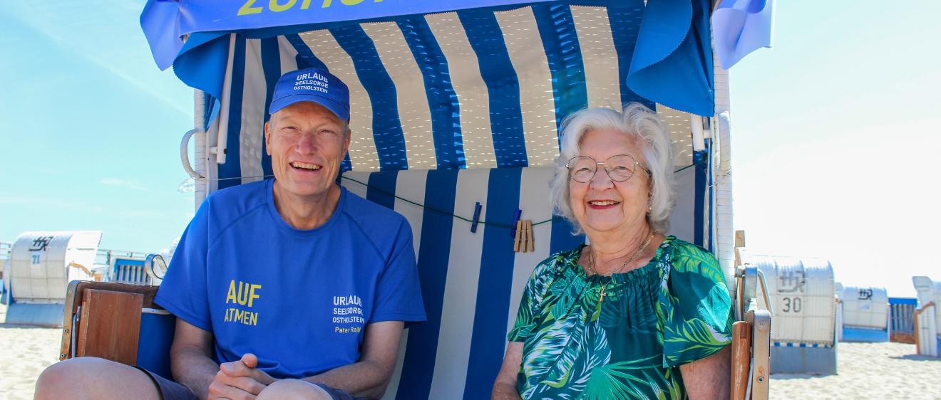 Urlauberseelsorger Pater Ralf Winterberg sitzt mit Touristin Anita Wendt im Ostseebad Dahme in einem „Zuhör-Korb“.