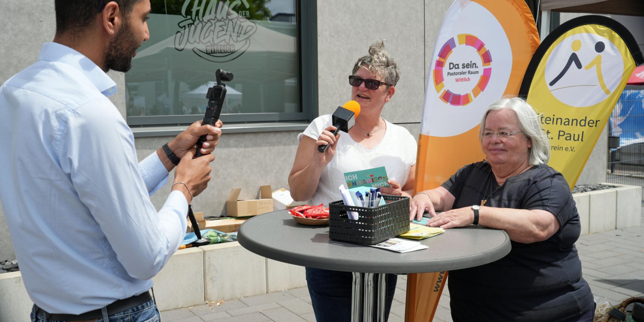 Achmed Mohamed zeichnet Videoclips auf von Menschen, die sich engagieren – hier von Susanne Briese und Karin Ballmann (von links). (c) Stefan Endres Achmed Mohamed zeichnet Videoclips auf von Menschen, die sich engagieren – hier von Susanne Briese und Karin Ballmann (von links).