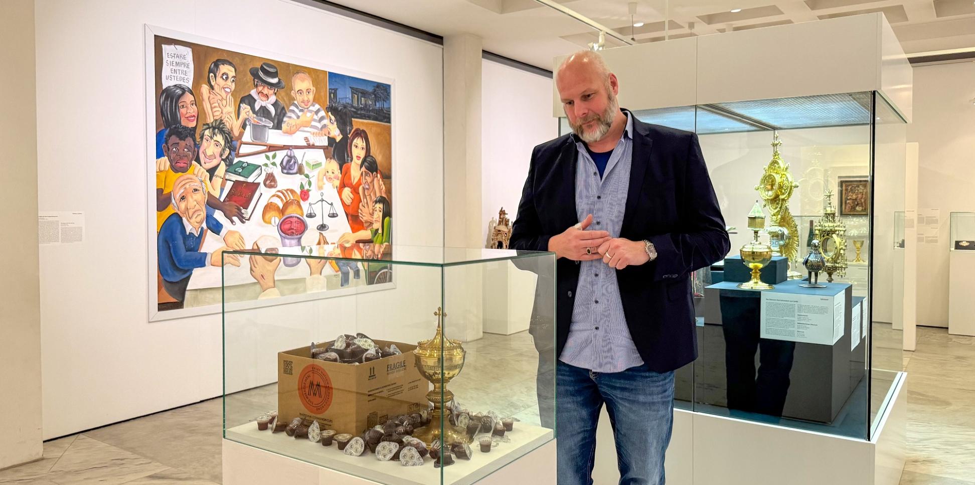 Jürgen von Ahn betrachtet das Exponat „Gold oder Plastik?“ in der Ausstellung „Das letzte Abendmahl“.