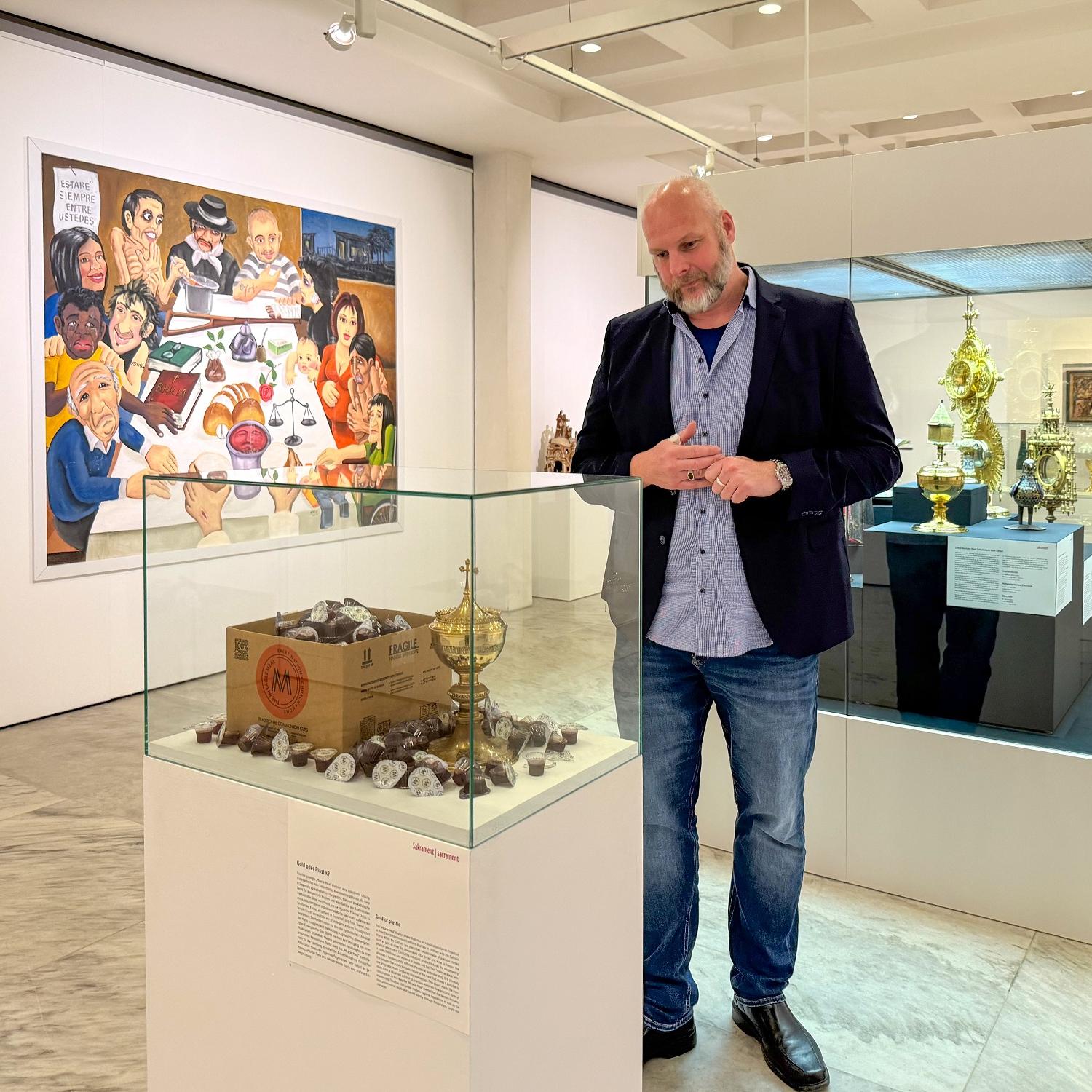 Jürgen von Ahn betrachtet das Exponat „Gold oder Plastik?“ in der Ausstellung „Das letzte Abendmahl“.