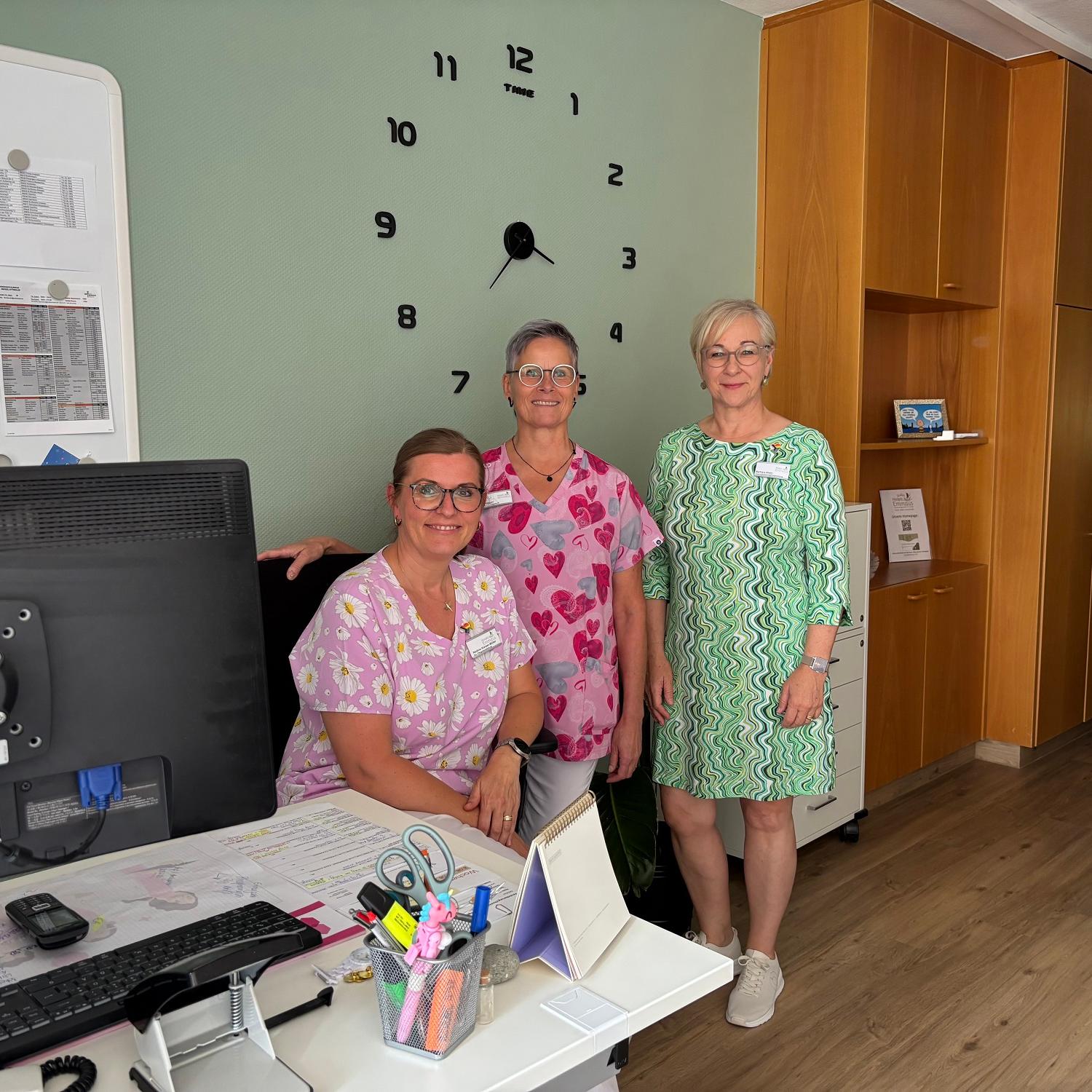 Hospizleiterin Barbara Klein (links) und Palliativ-Pflegefachkraft Iris Kirchen sitzen gemeinsam an einem Tisch unter einem Klimagerät.