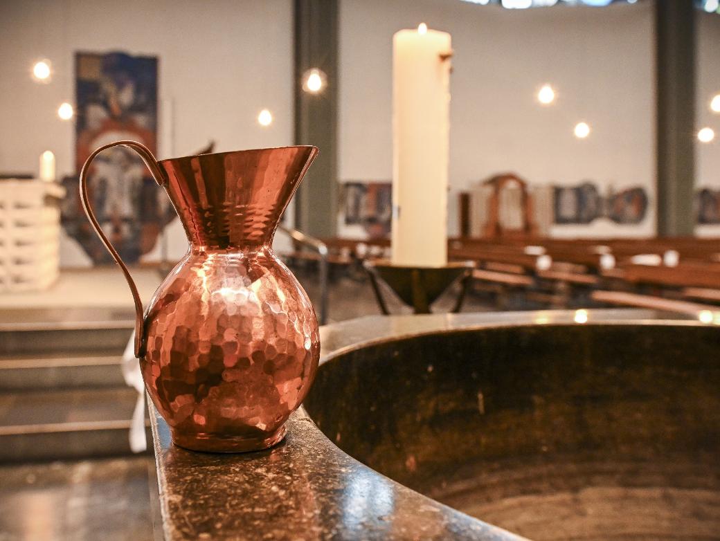 Ein Krug steht auf dem Rand eines Taufbeckens.