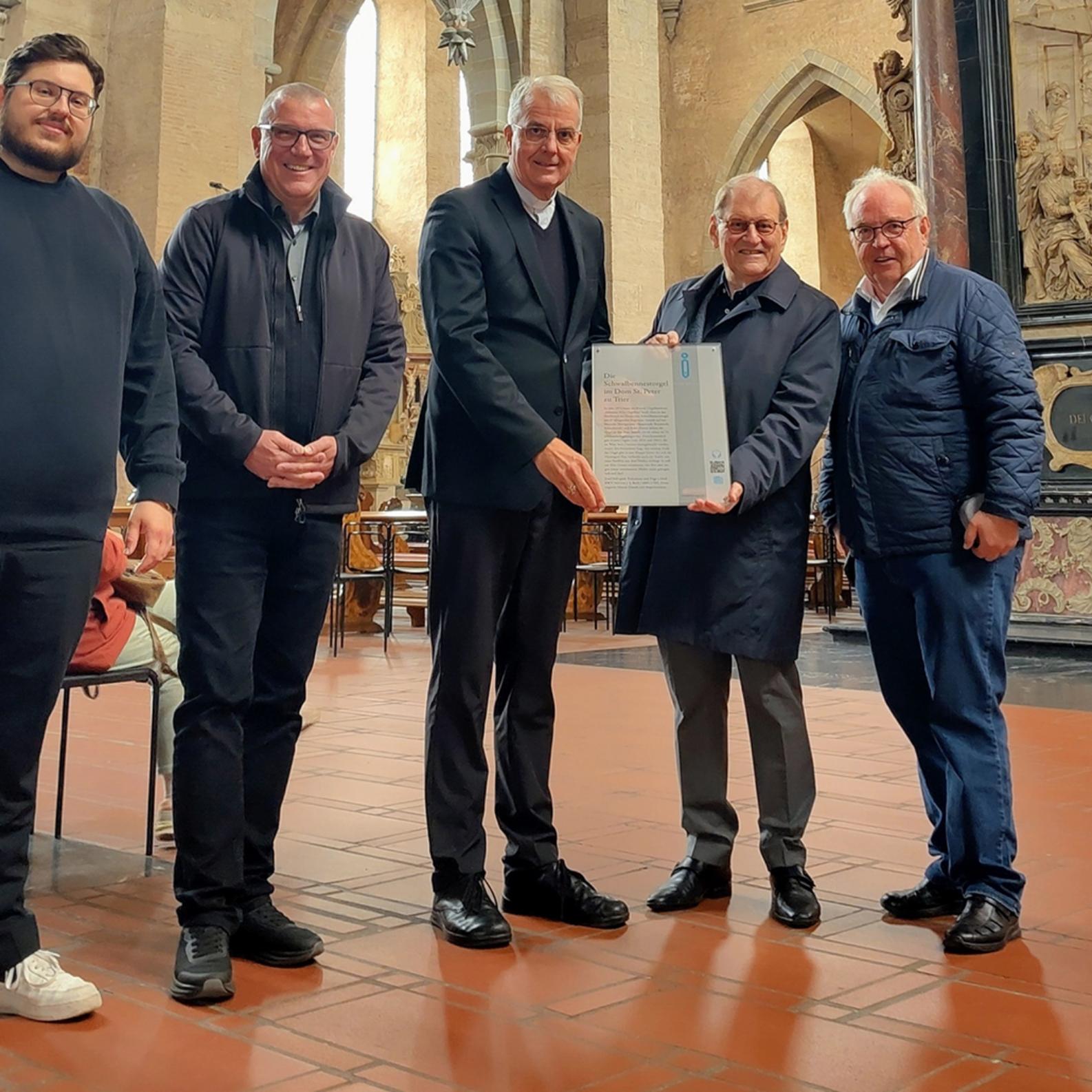 Hermann Lewen und Prof. Dr. Oscar Gabriel übergeben die Infotafel an Dompropst Weihbischof Jörg Michael Peters, Domkapitular Matthias Struth und Domorganist Marcel Eliasch (von rechts).