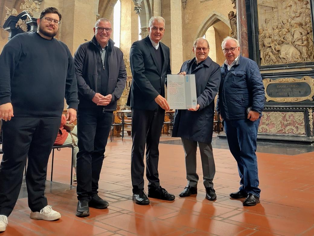 Hermann Lewen und Prof. Dr. Oscar Gabriel übergeben die Infotafel an Dompropst Weihbischof Jörg Michael Peters, Domkapitular Matthias Struth und Domorganist Marcel Eliasch (von rechts).