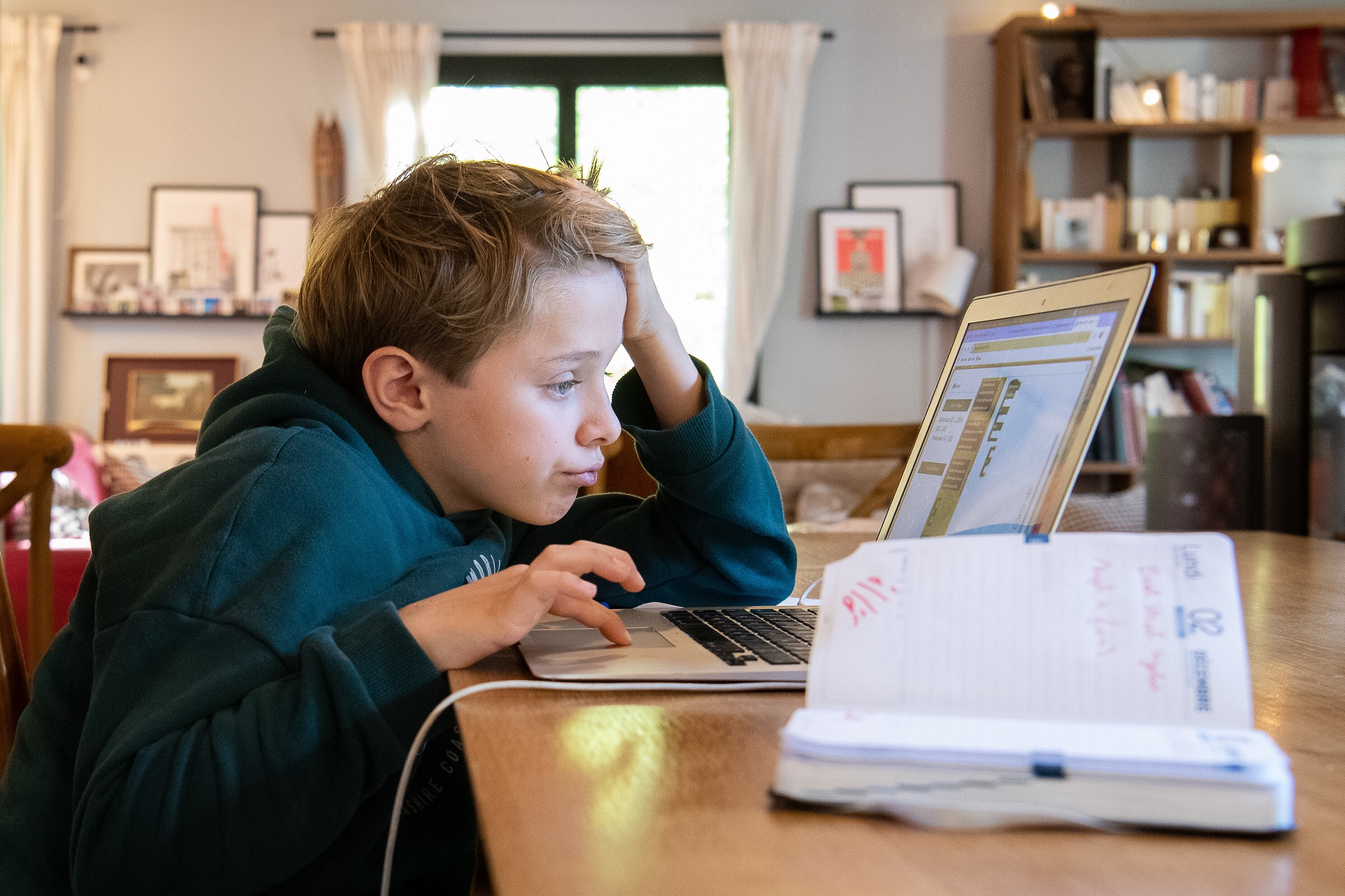 Schüler sitzt am Computer und arbeitet an seinen Hausaufgaben.