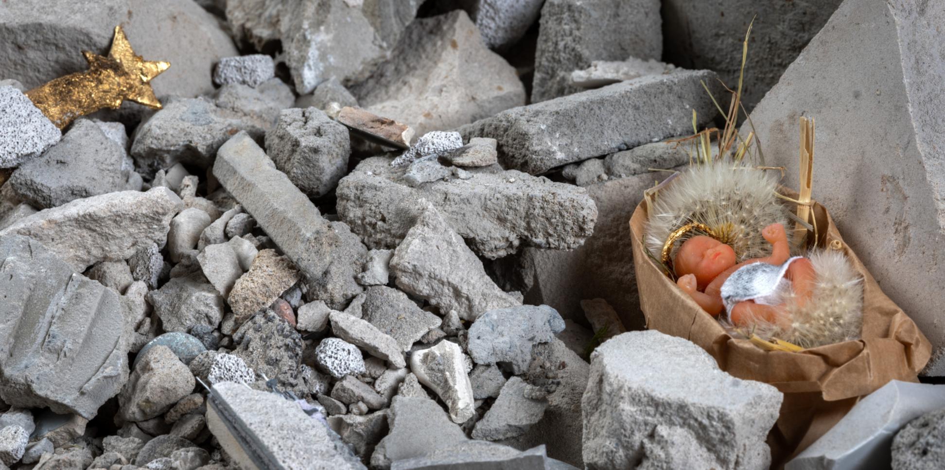 Das Kunstwerk 'Krippe im Schutt' zeigt das Baby in einer Schubkarre mit Schutt.