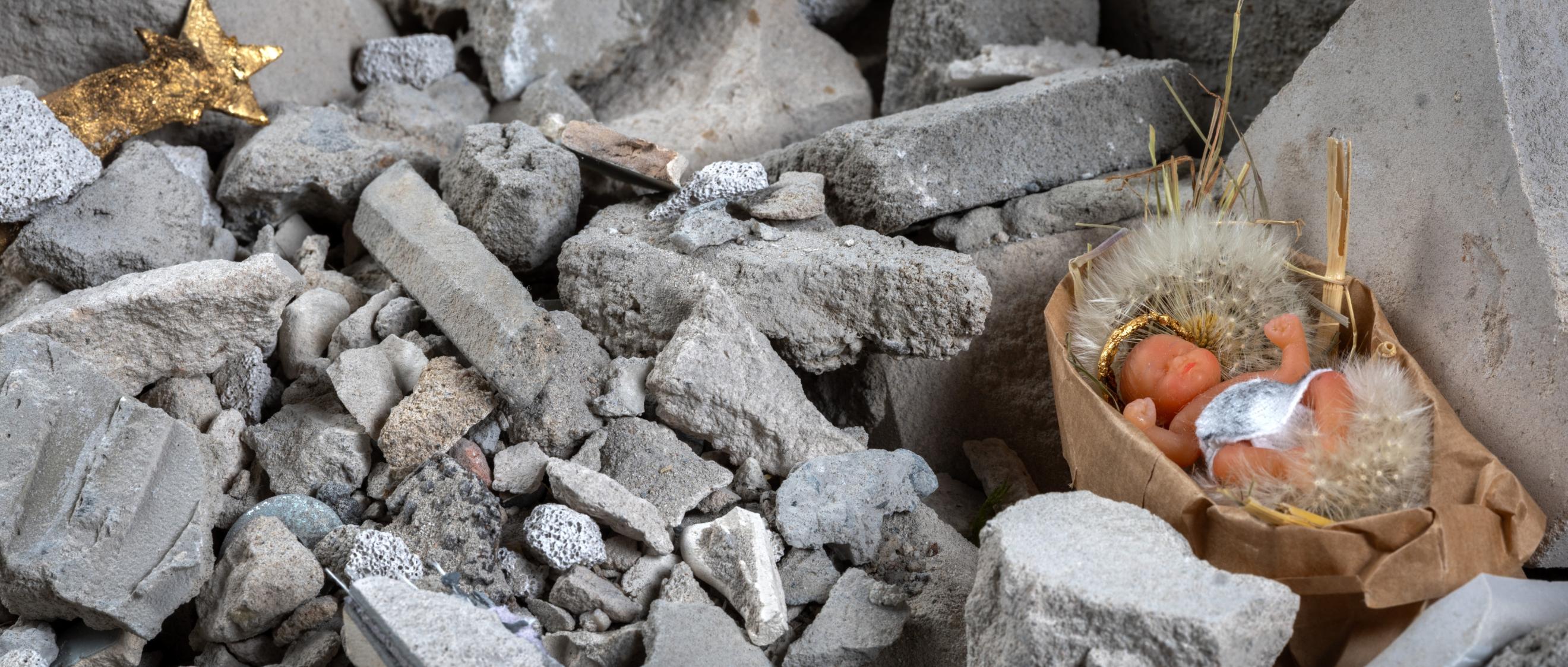 Das Kunstwerk 'Krippe im Schutt' zeigt das Baby in einer Schubkarre mit Schutt.