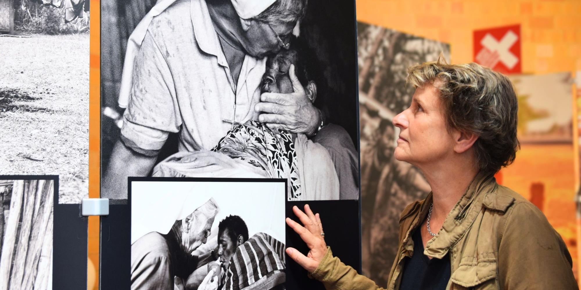 Eine Frau betrachtet schwarz-weiß-Fotografien auf großen Leinwänden (c) missio Aachen Eine Frau betrachtet schwarz-weiß-Fotografien auf großen Leinwänden