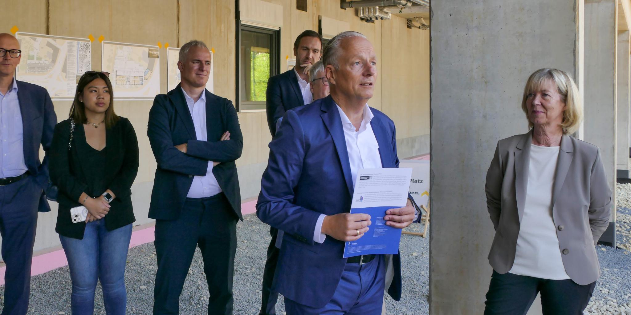 Ein Mann hält eine Rede, mehrere Personen stehen drumherum (c) Rolf Lorig Ein Mann hält eine Rede, mehrere Personen stehen drumherum