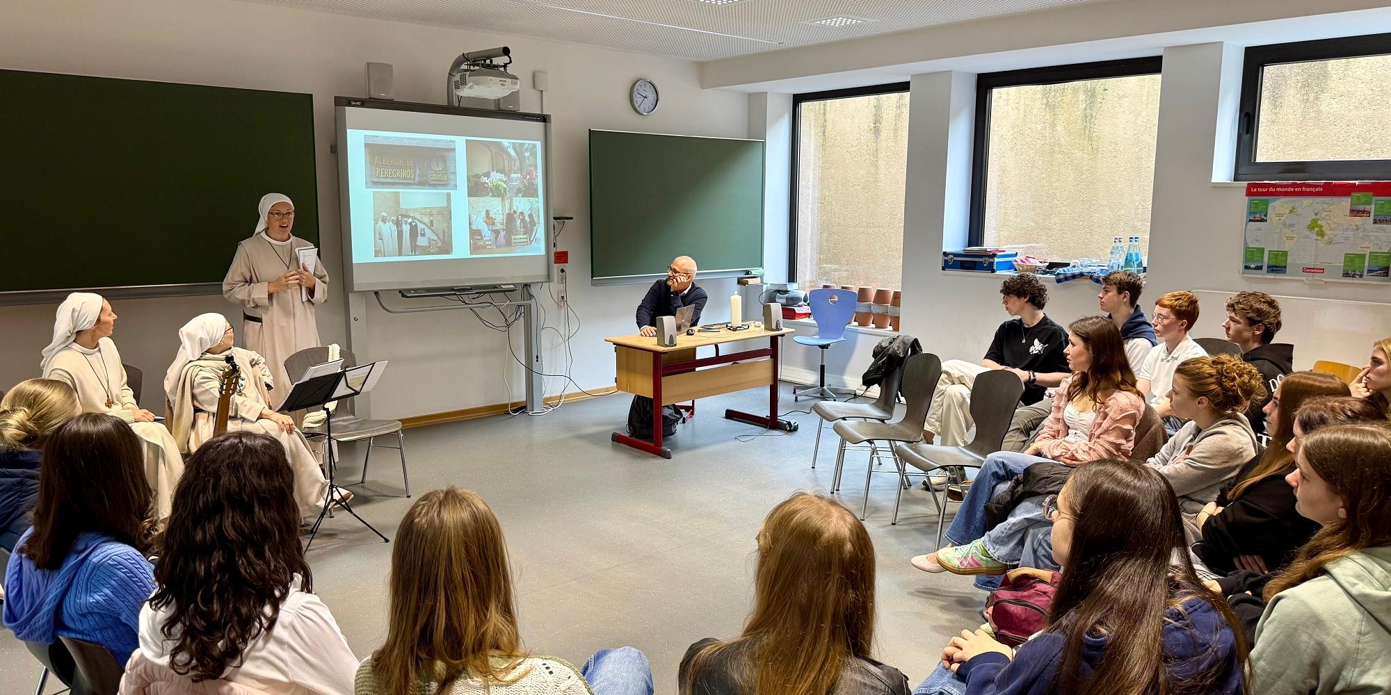 Drei spanische Ordensschwestern beim Vortrag vor einer Klasse.
