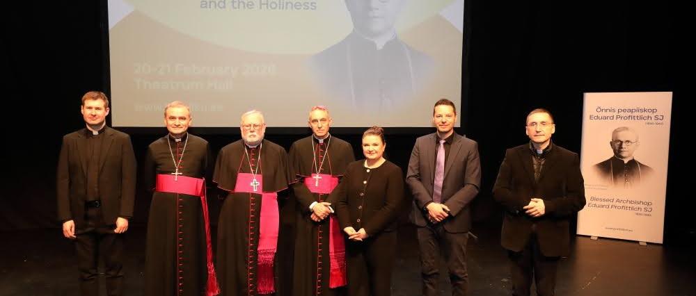 Gruppenbild mit Dr. Thorsten Hoffmann (zweiter von rechts) vor Projektion und Plakat von Bischof Profittlich.