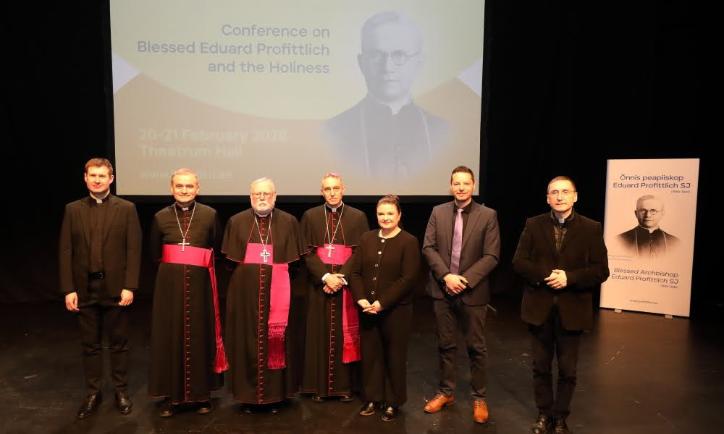 Gruppenbild mit Dr. Thorsten Hoffmann (zweiter von rechts) vor Projektion und Plakat von Bischof Profittlich.