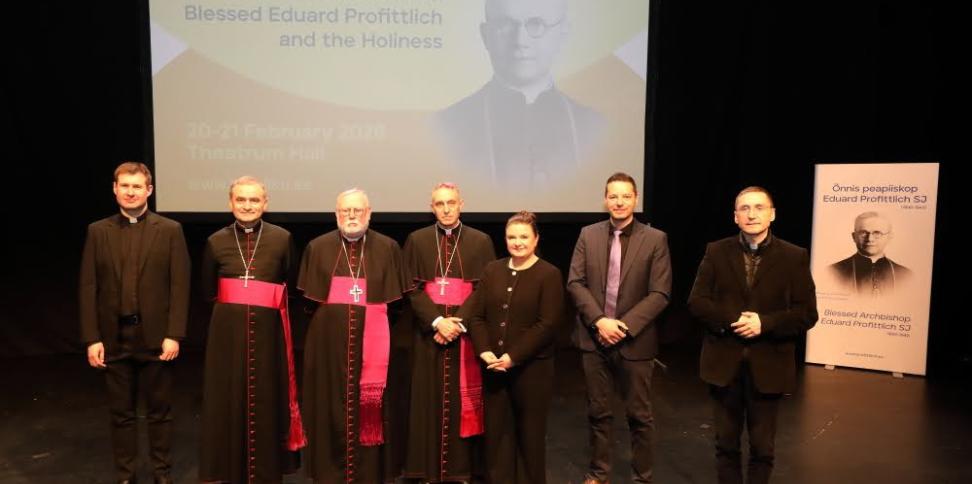 Gruppenbild mit Dr. Thorsten Hoffmann (zweiter von rechts) vor Projektion und Plakat von Bischof Profittlich.