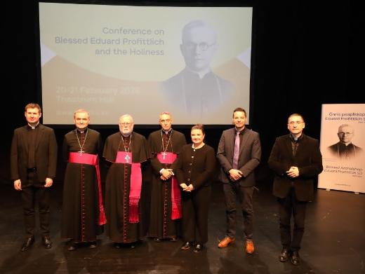 Gruppenbild mit Dr. Thorsten Hoffmann (zweiter von rechts) vor Projektion und Plakat von Bischof Profittlich.