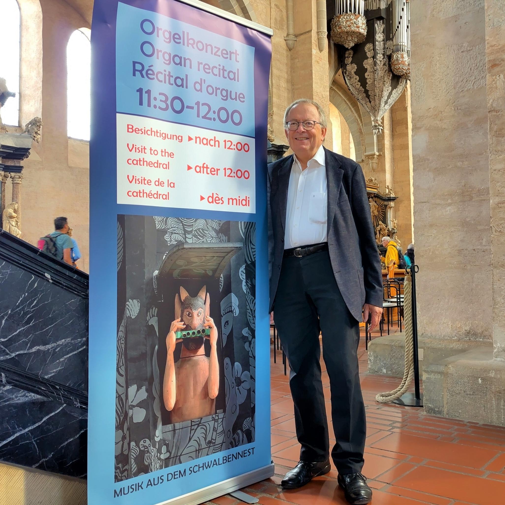 Ein Mann steht vor einem Plakat in einer Kirche