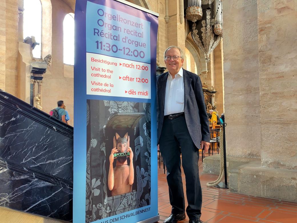Ein Mann steht vor einem Plakat in einer Kirche