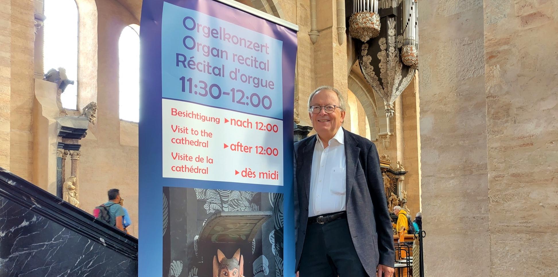 Ein Mann steht vor einem Plakat in einer Kirche