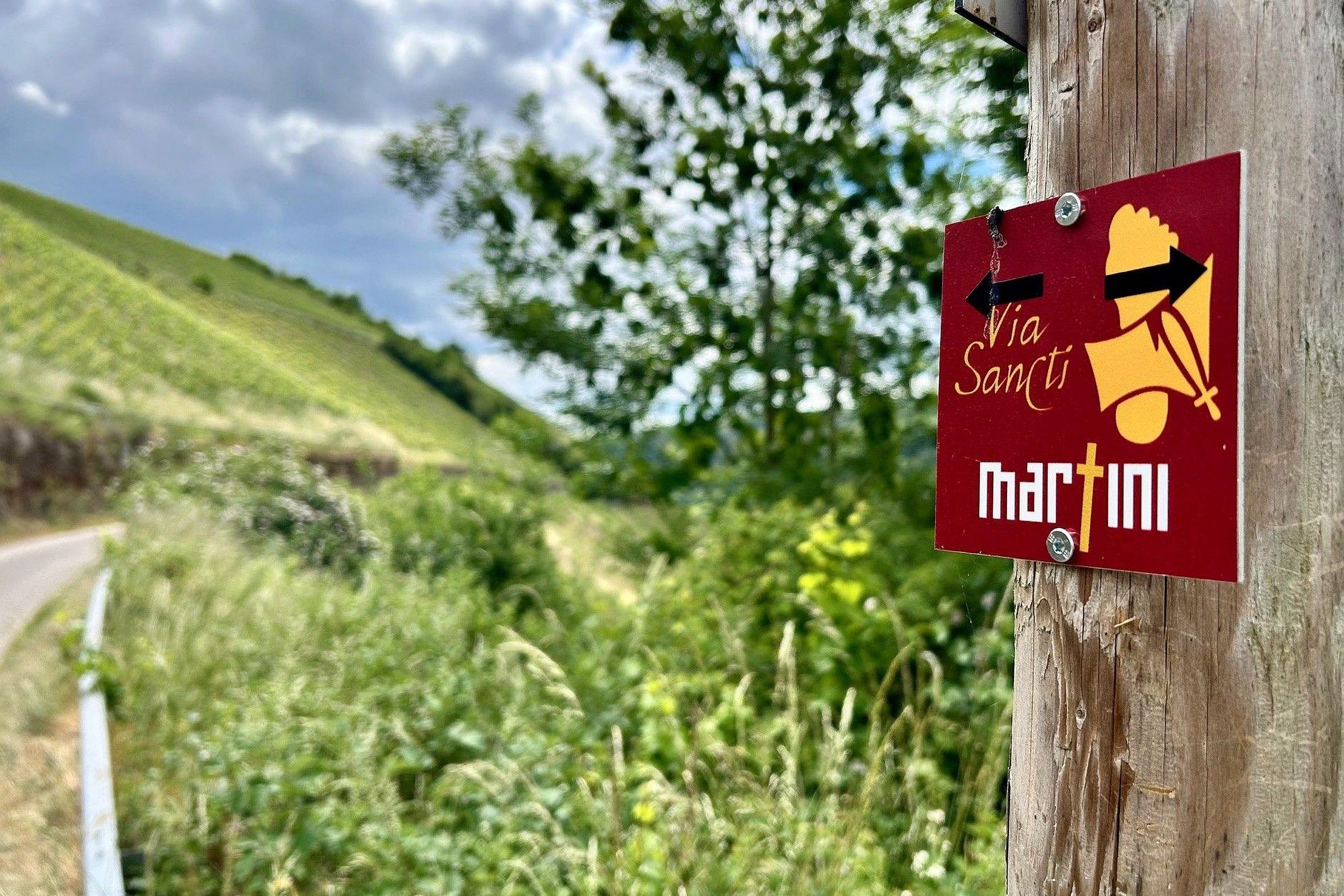 Kleine rote Hinweisschilder weisen Pilger und Spaziergänger auf die Streckenführung des Europäischen Martinswegs hin.