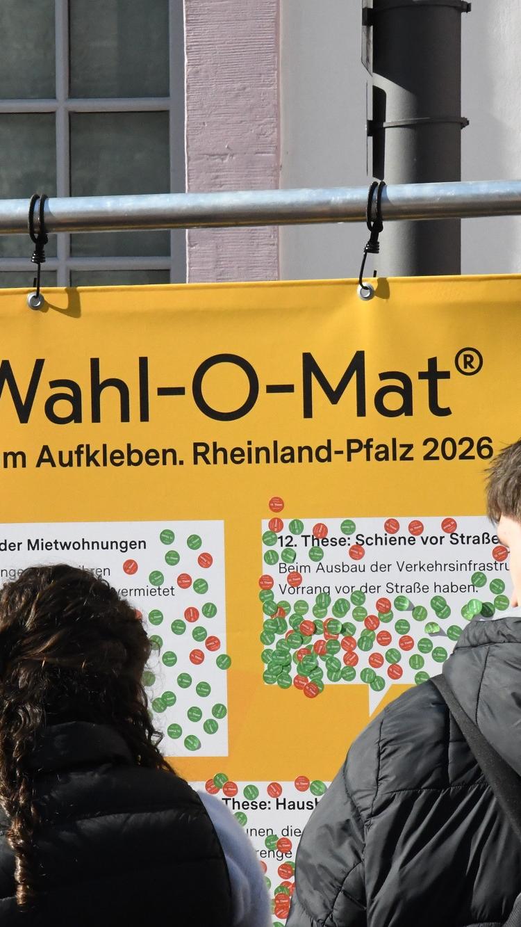 Jugendliche vor dem Wahl-O-Mat-Plakat.