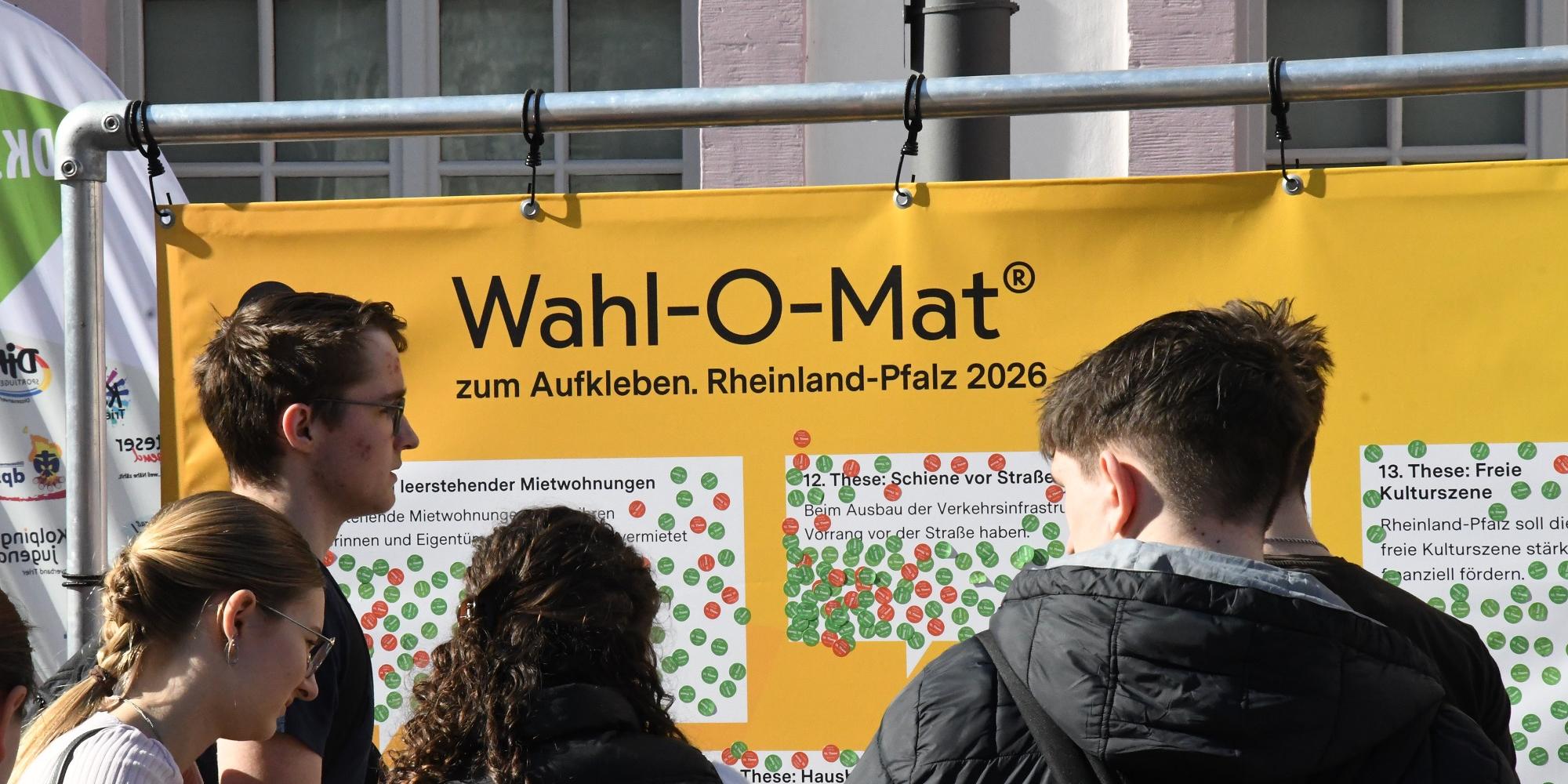 Jugendliche vor dem Wahl-O-Mat-Plakat.