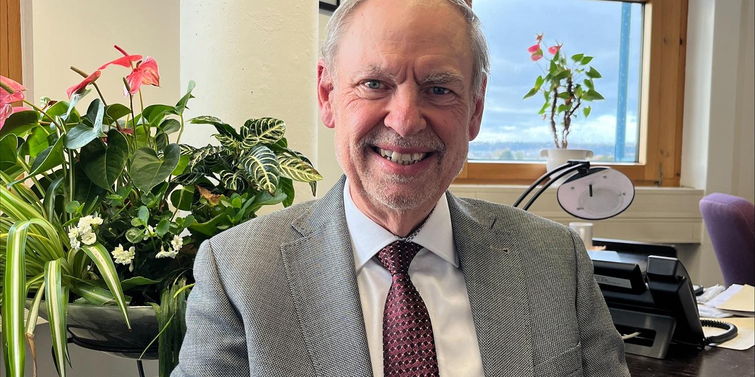 Ein Mann mit Krawatte blickt lächelnd in die Kamera (c) Sara Ein Mann mit Krawatte blickt lächelnd in die Kamera