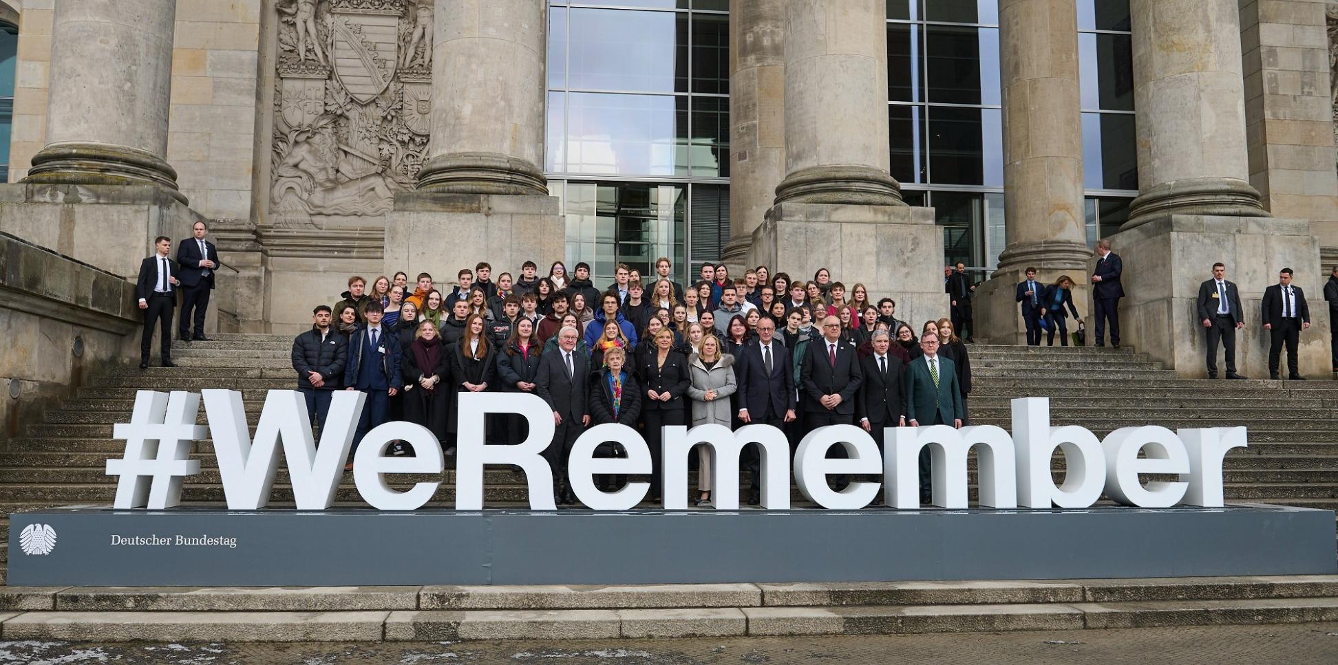 Bundestagsabgeornete auf der Reichstagstreppe vor Schriftzug 'WeRemember