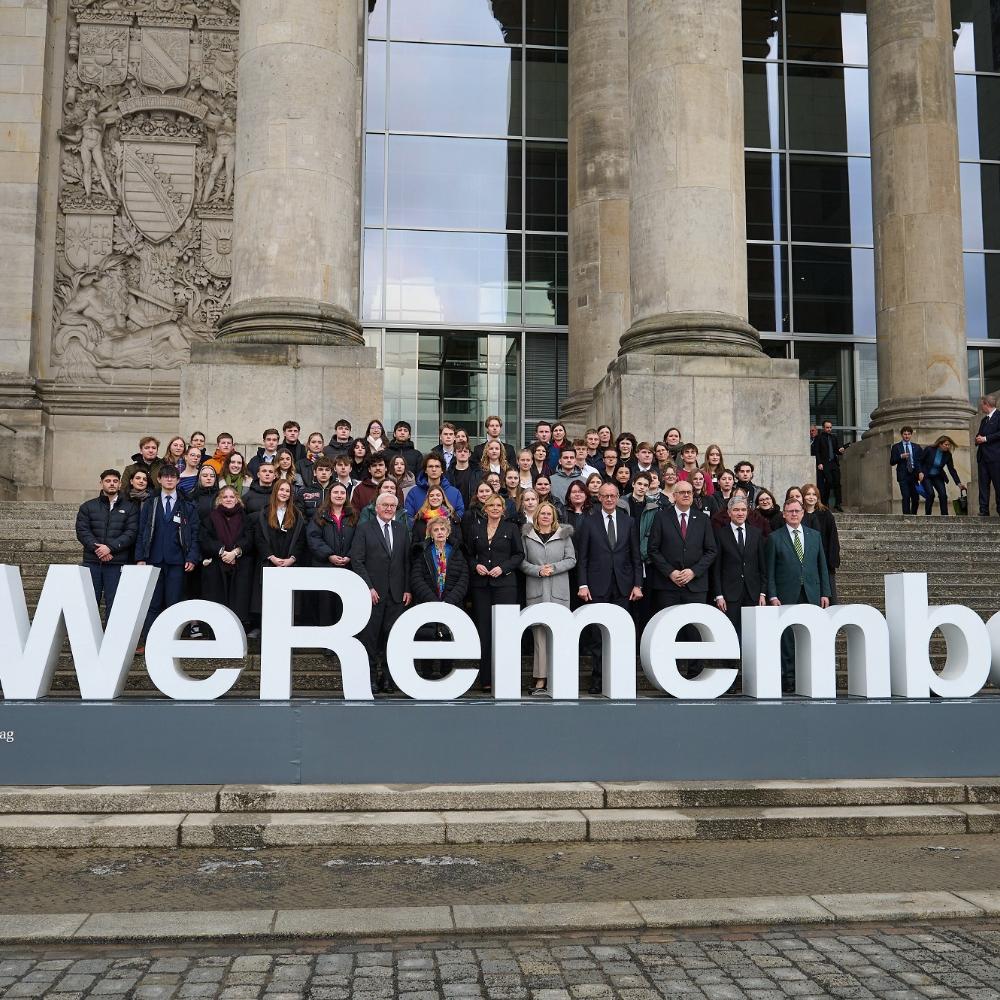 Bundestagsabgeornete auf der Reichstagstreppe vor Schriftzug 'WeRemember