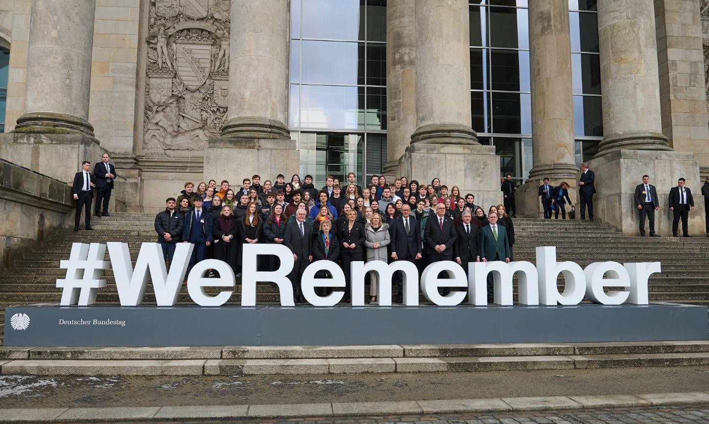 Bundestagsabgeornete auf der Reichstagstreppe vor Schriftzug 'WeRemember