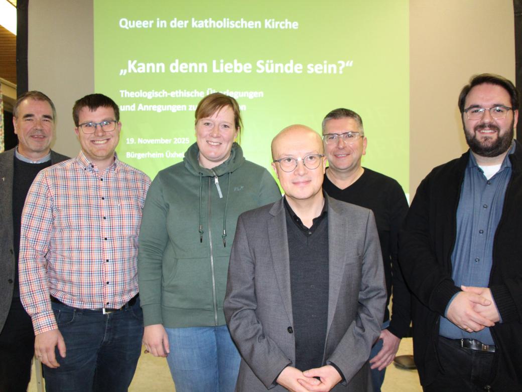 Sechs Personen stehen vor einer grünen Leinwand und lächeln in die Kamera