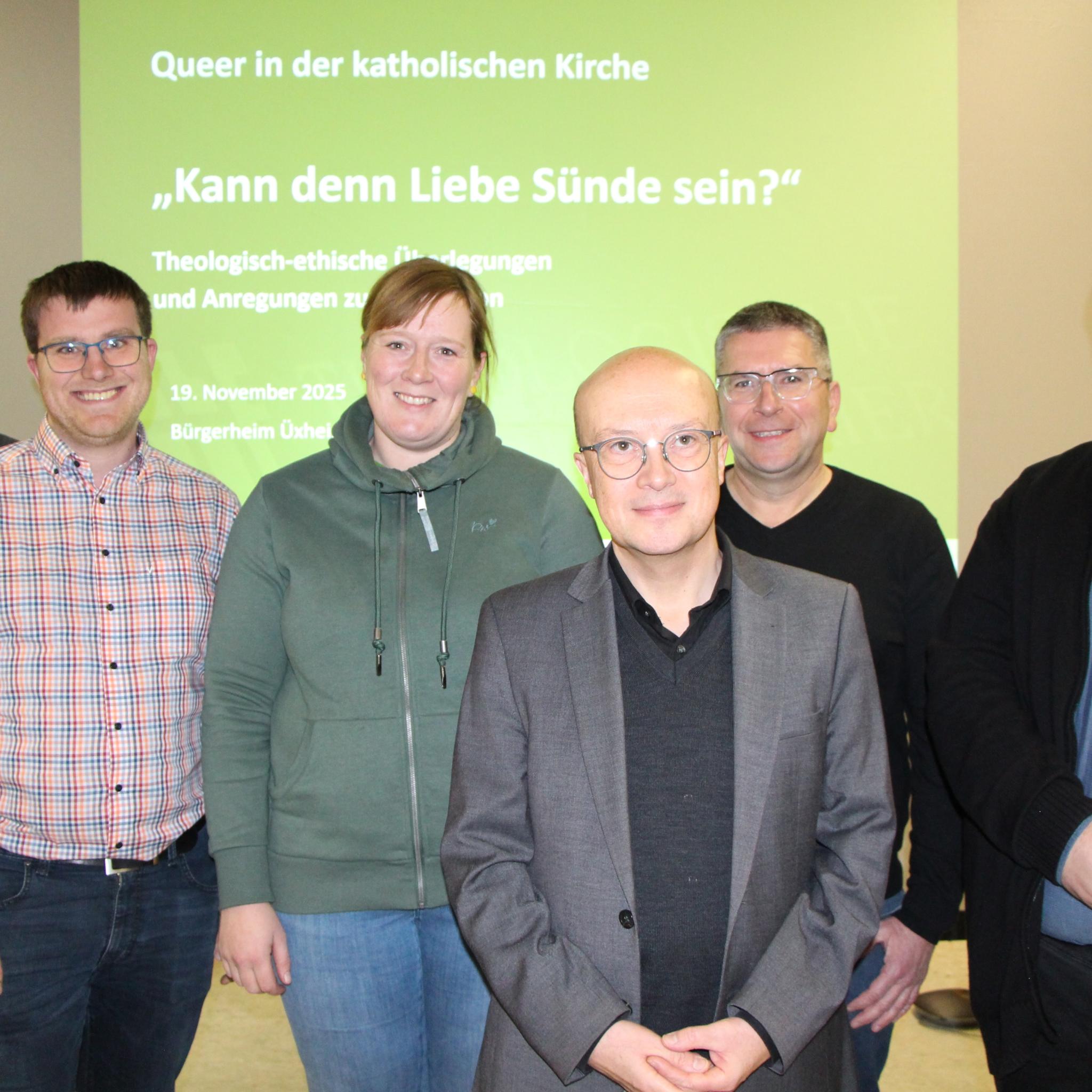 Sechs Personen stehen vor einer grünen Leinwand und lächeln in die Kamera