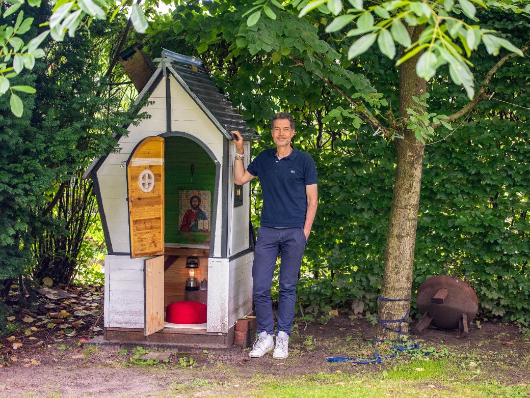 Christian Busemann steht neben dem zur Kapelle umgebauten ehemaligen Spielhaus der Kinder in seinem Garten in Hamburg.