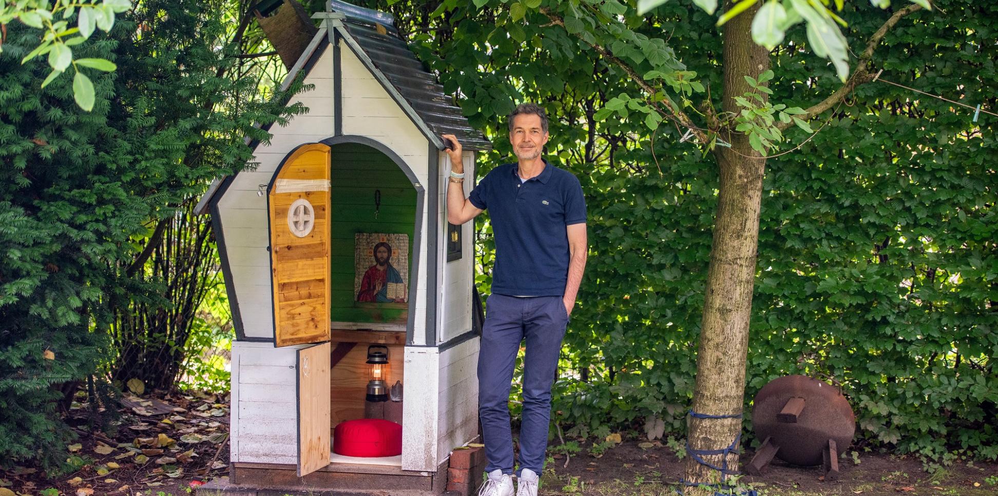 Christian Busemann steht neben dem zur Kapelle umgebauten ehemaligen Spielhaus der Kinder in seinem Garten in Hamburg.