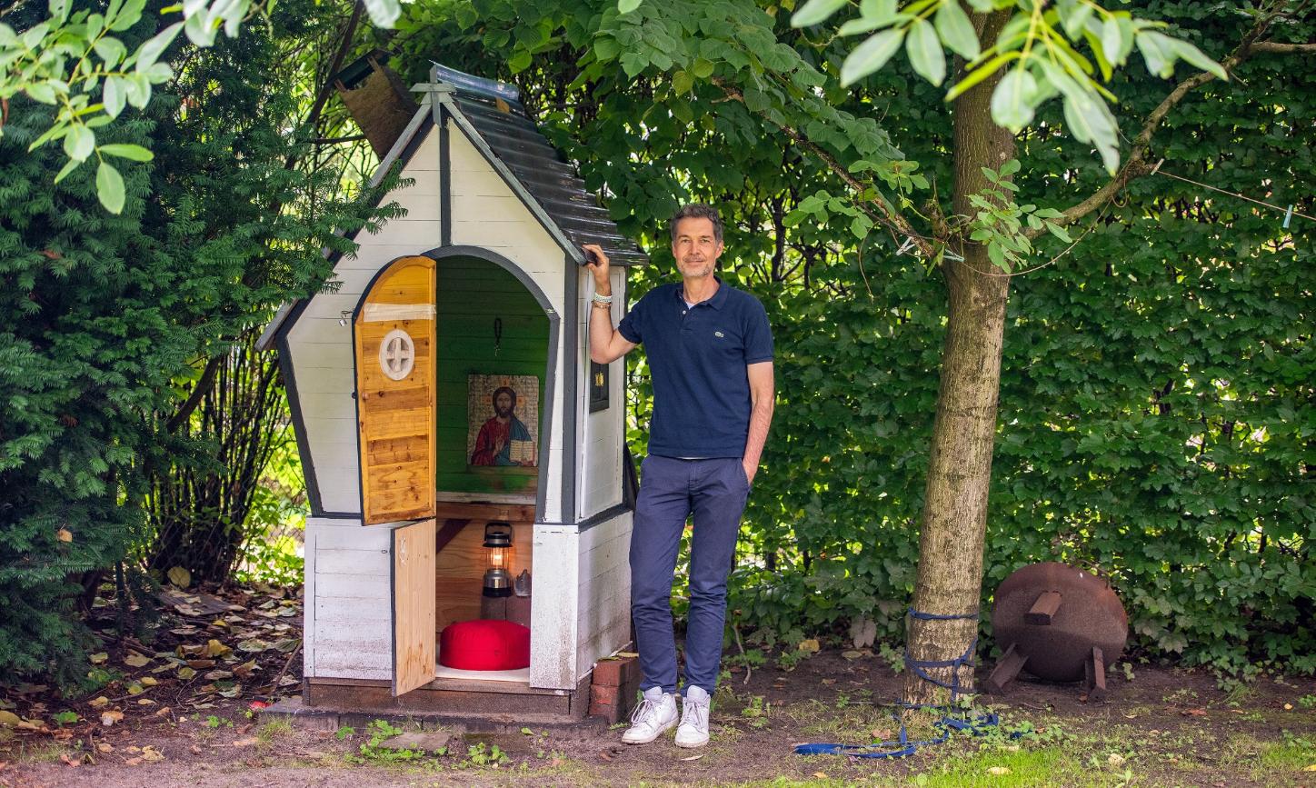 Christian Busemann steht neben dem zur Kapelle umgebauten ehemaligen Spielhaus der Kinder in seinem Garten in Hamburg.