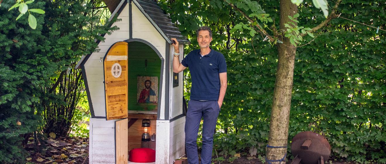 Christian Busemann steht neben dem zur Kapelle umgebauten ehemaligen Spielhaus der Kinder in seinem Garten in Hamburg.