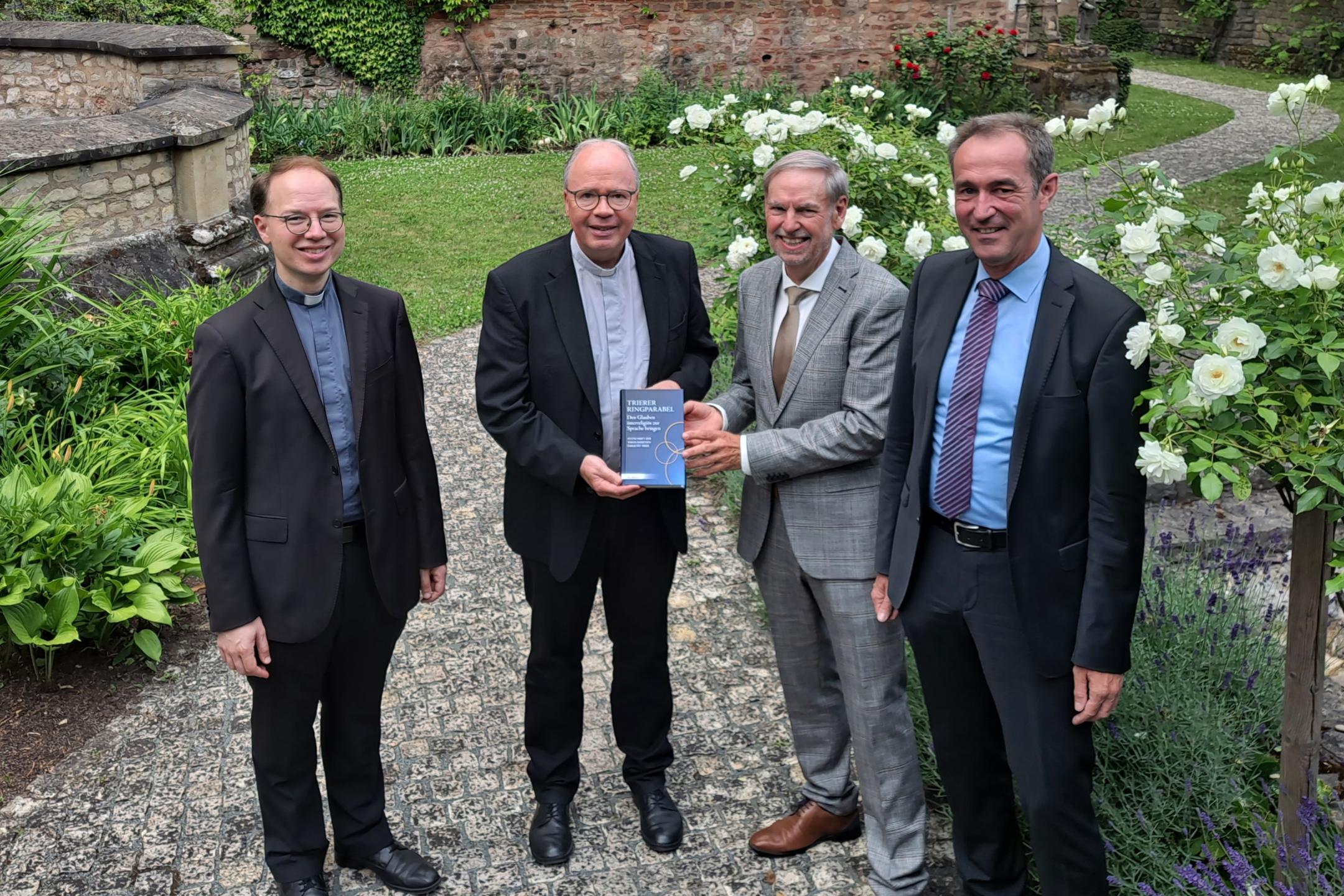 Gruppenbild: Bischof Ackermann (Zweiter von links) erhielt ein erstes Exemplar der Festschrift von (von links) Professor  Marco Benini, Rektor Walter Andreas Euler und Klaus Vellguth.