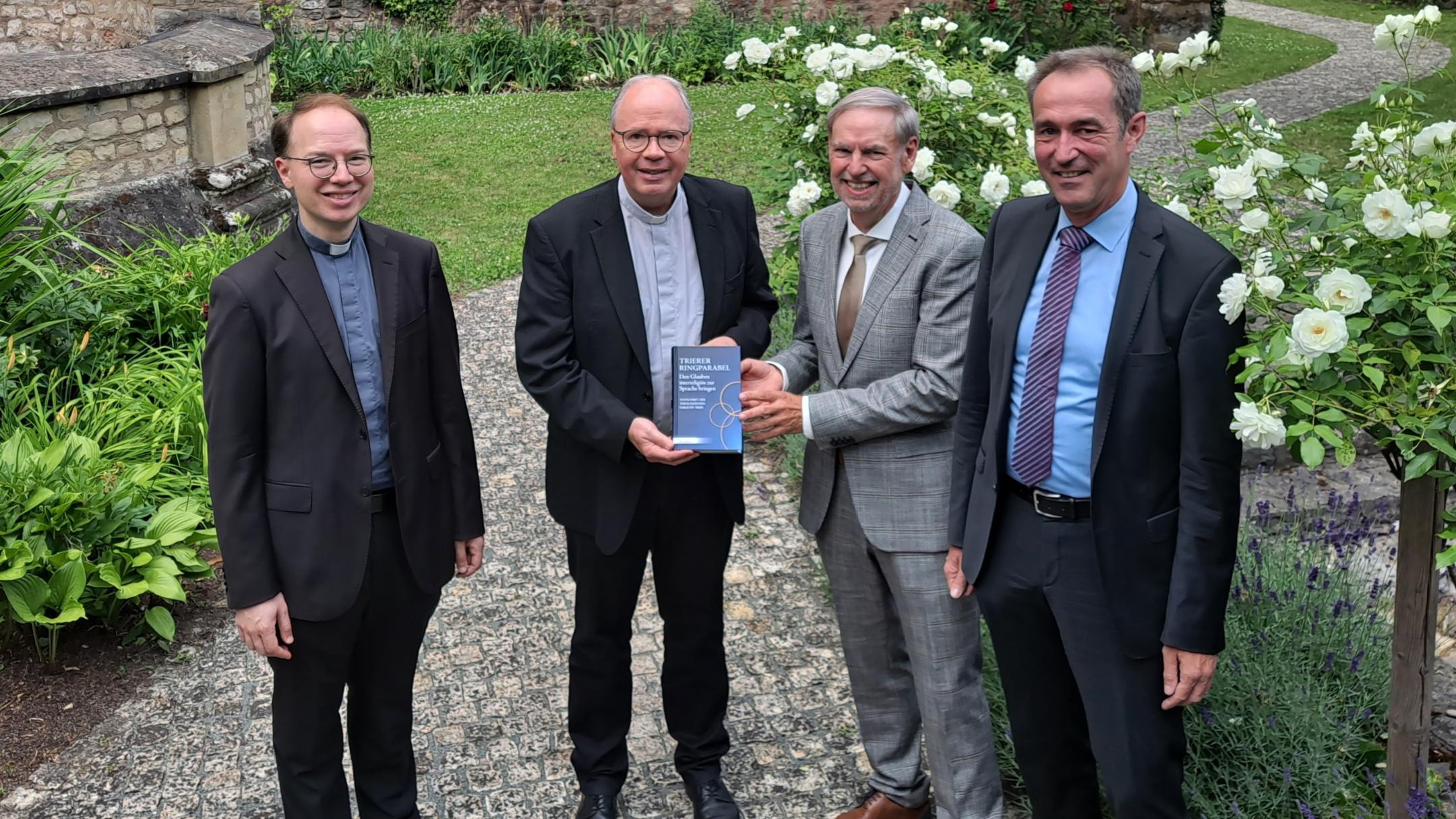 Gruppenbild: Bischof Ackermann (Zweiter von links) erhielt ein erstes Exemplar der Festschrift von (von links) Professor  Marco Benini, Rektor Walter Andreas Euler und Klaus Vellguth.