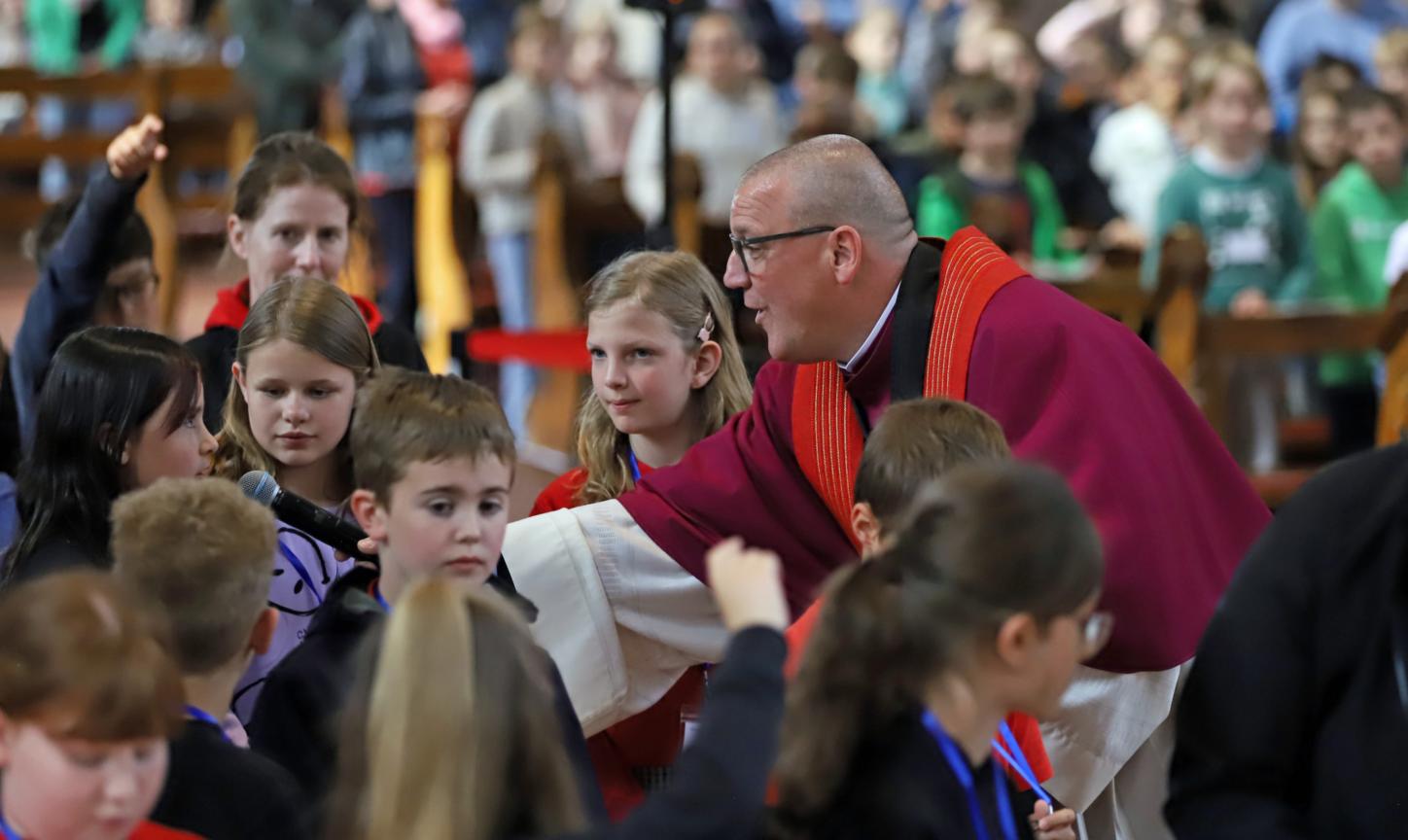 Domkapitular Matthias Struth mit Kindern beim Gottesdienst anlässlich der Heilig-Rock-Tage 2025.