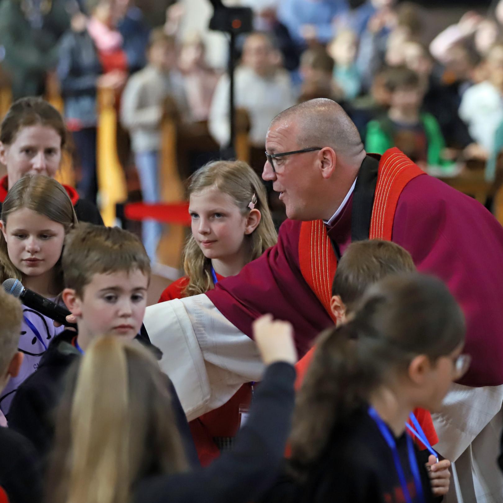 Domkapitular Matthias Struth mit Kindern beim Gottesdienst anlässlich der Heilig-Rock-Tage 2025.