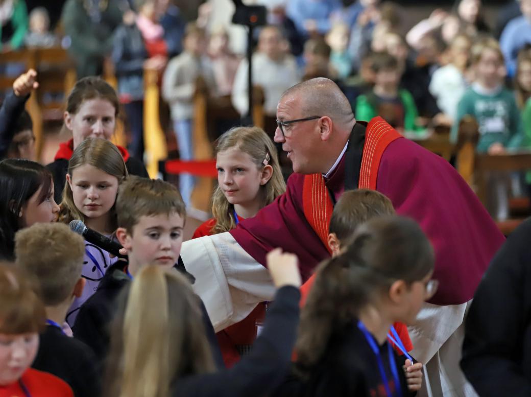 Domkapitular Matthias Struth mit Kindern beim Gottesdienst anlässlich der Heilig-Rock-Tage 2025.